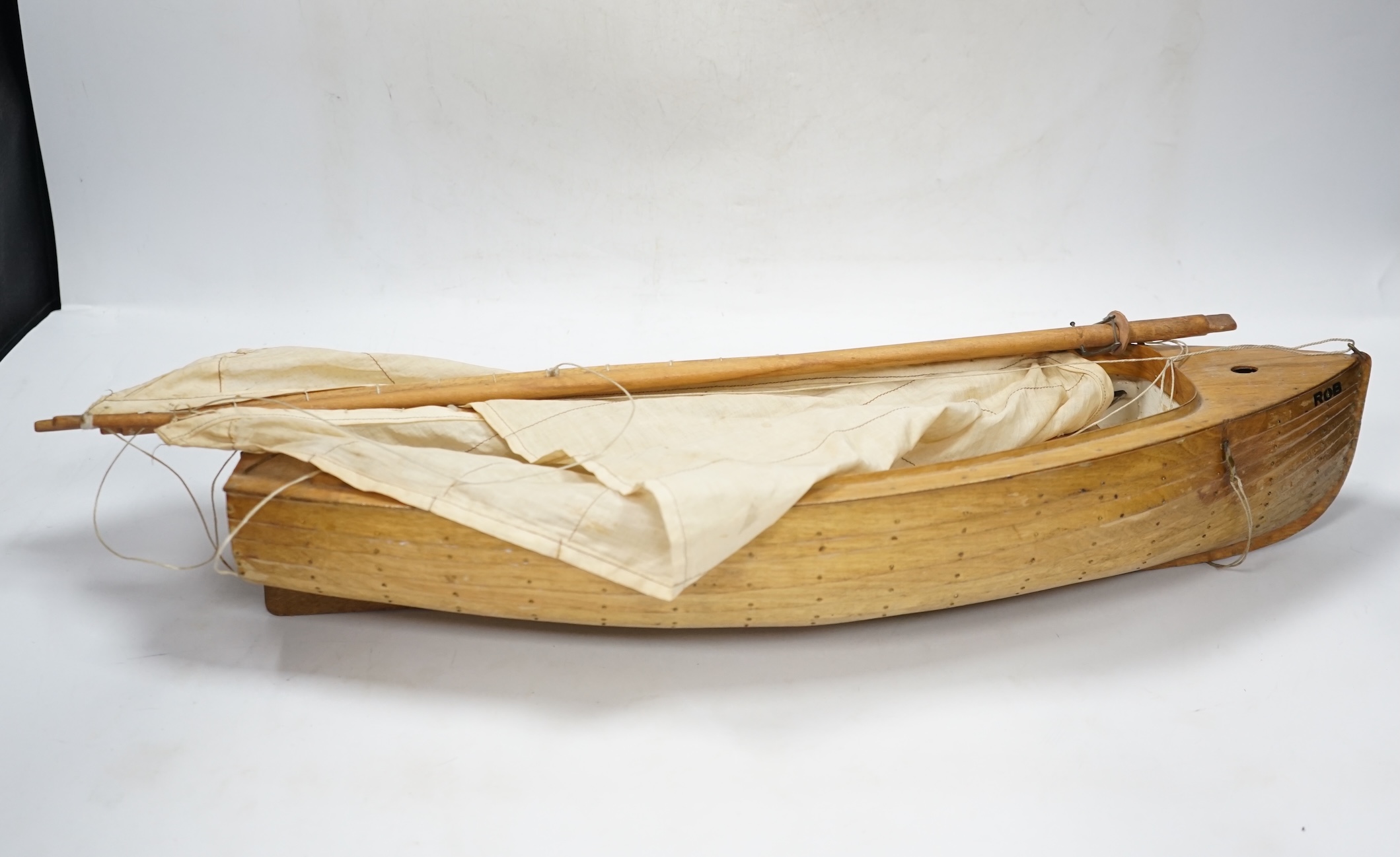 A mid 20th century kit built wooden model sailing boat, ‘Rob’, of plank on frame construction with white painted interior, hull 45cm long. Condition - fair to good.